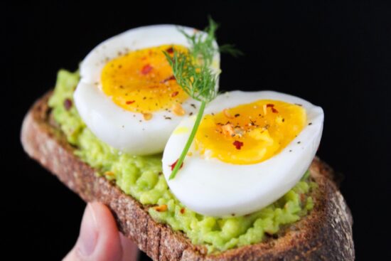 boiled egg on a bread smeared with avocado puree