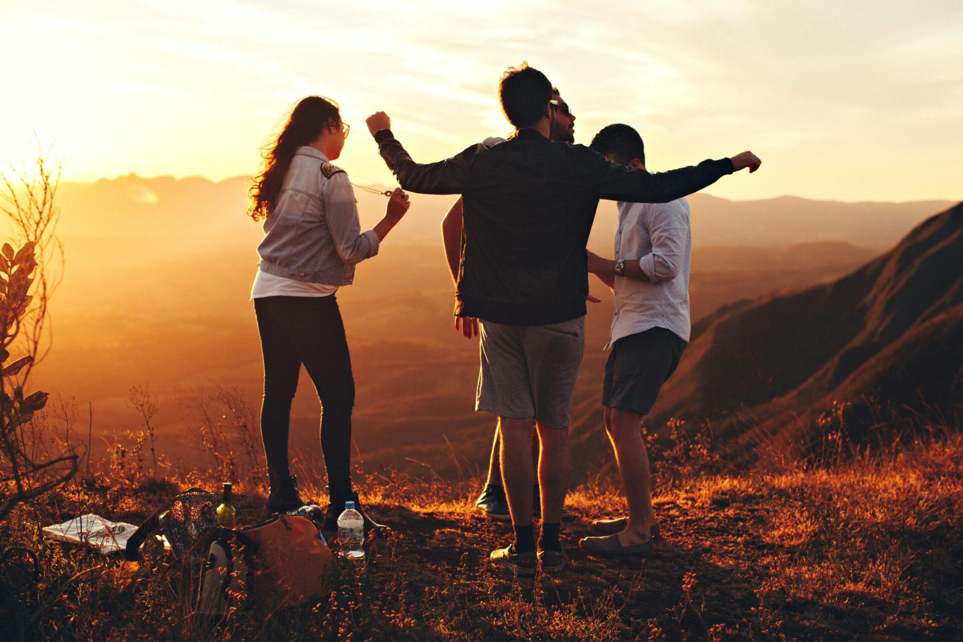 folks on a hill top amidst nature enjoying sunset