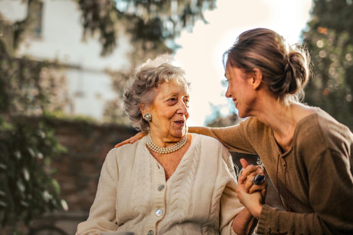 girl caring for an elderly lady and having a chat